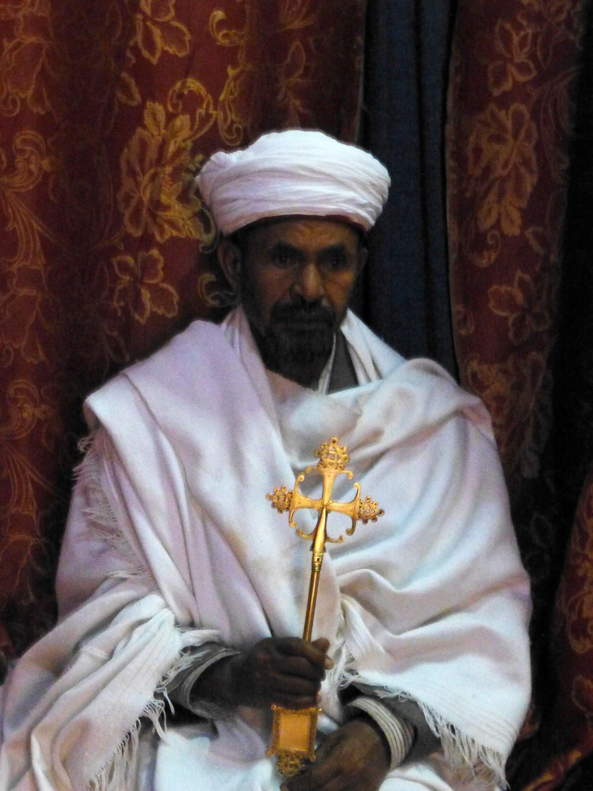 A priest with a hand cross at Bete Giyorgis, Lalibela