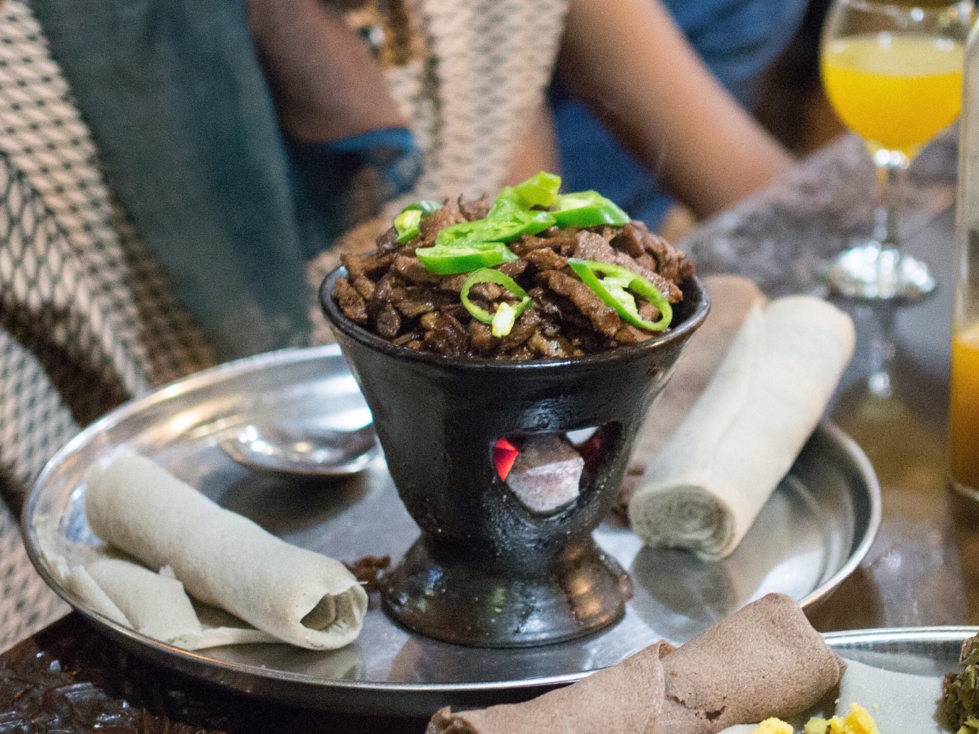 Tibs, sautéed meat served in a clay pot with injera