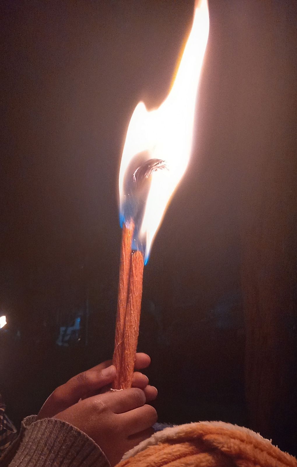 A lit tuaf candle held in the hand